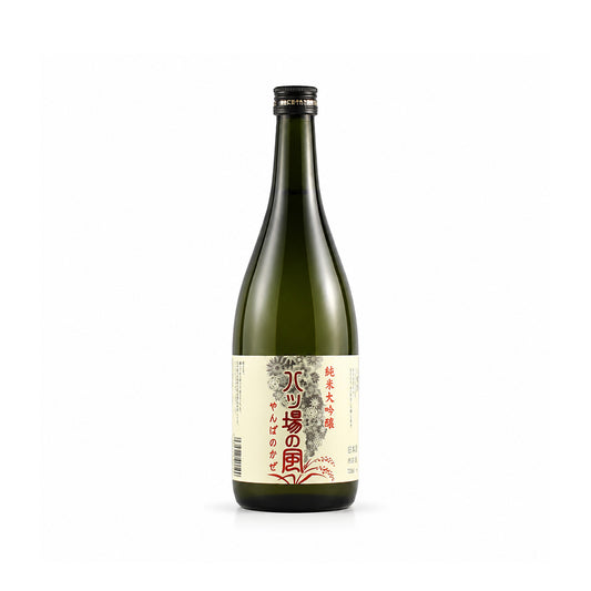 A single bottle of Japanese sake, likely Junmai rice wine, in a dark green glass bottle with a cream-colored label featuring red and black Japanese text, set against a plain white background.